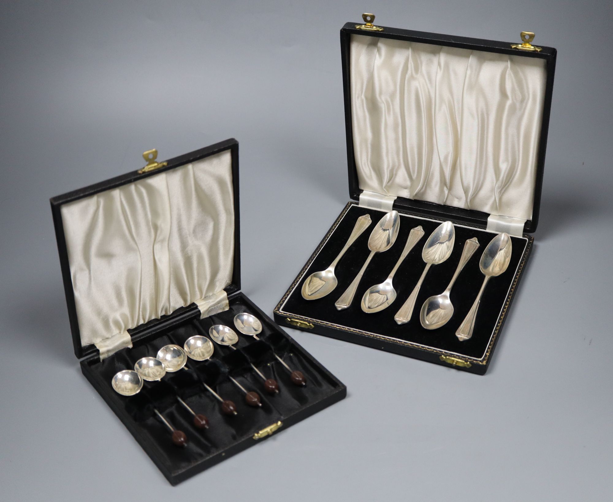 A 1930s cased set of six bean end silver coffee spoons and a later set of six silver grapefruit spoons.